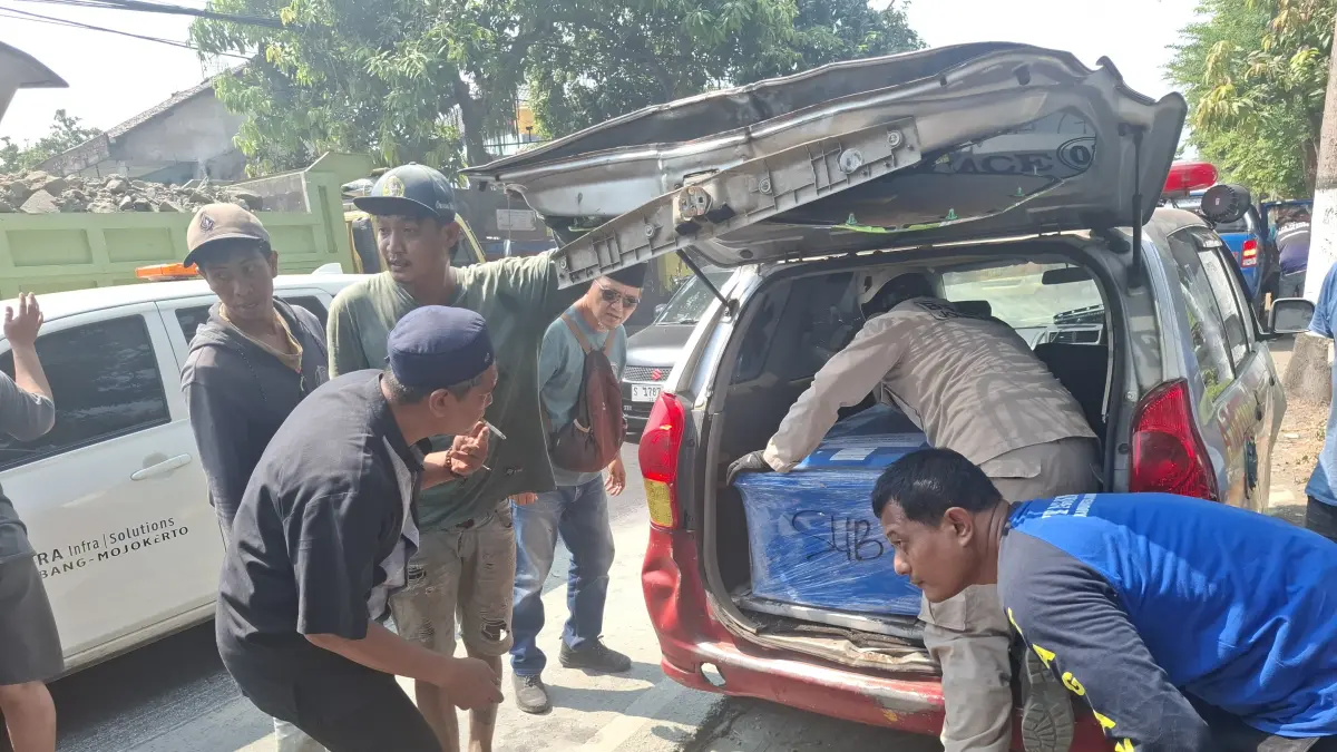 Proses pemindahan jenazah dari ambulans yang terlibat kecelakaan ke mobil ambulans baru