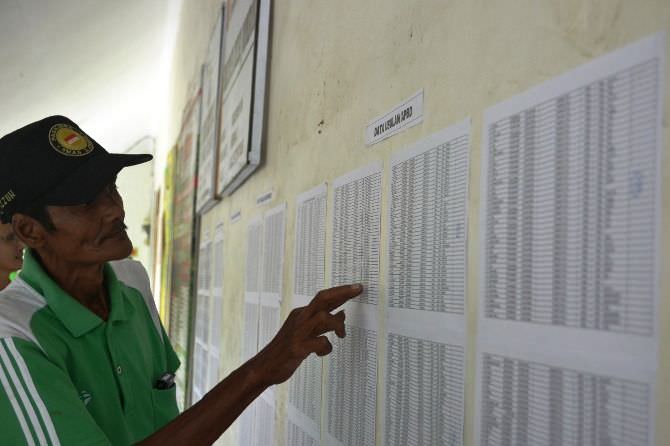 Ilustrasi warga memeriksa daftar penerima manfaat dari pemerintah di Jombang