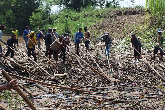 JOMBANG – Material sampah berupa kayu sempat menyumbat aliran kali kon
