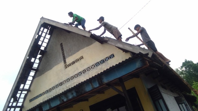 Beberapa sedang memperbaiki rumah yang rusak di Desa Ngudirejo akibat angin kencang Senin (13/6) sore.