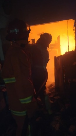 Petugas pemadam kebakaran saat melakukan pemadman api di rumah milik SUroso yang terbakar. (ISTIMEWA)