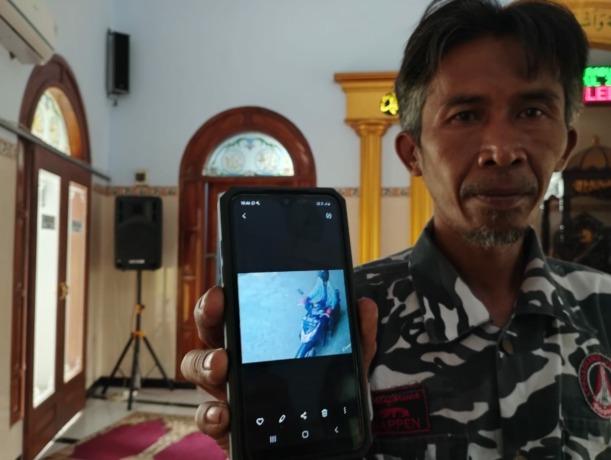 Iwan, saat menunjukkan foto pelaku pencurian kotak amal. (ACHMAD RW/JAWA POS RADAR JOMBANG)