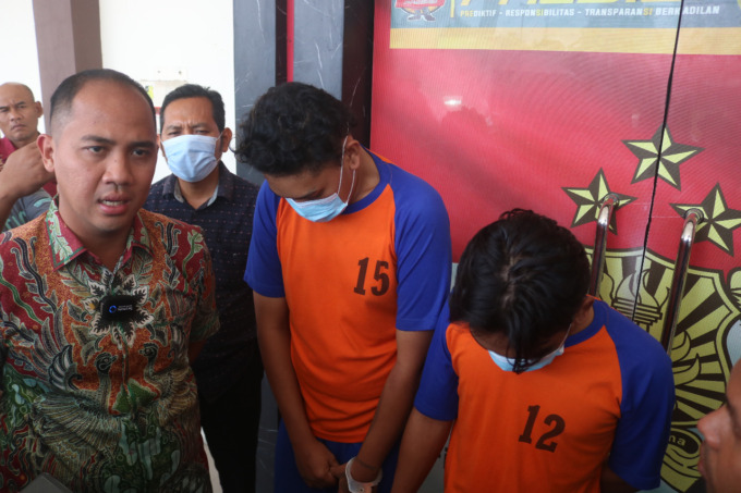 Dua pelaku pengeyokan di Jl Presiden Kh Abdurrahman Wahid saat diamankan petugas. (ACHMAD RW/JAWA POS RADAR JOMBANG)