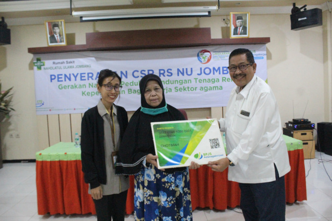Dr Bambang Dwi Hayunanto SpKK Direktur RSNU Jombang didampingi Kepala BPJS Ketenagakerjaan Cabang Jombang Binti Kristansi menyerahkan kartu BPJS kepada warga.