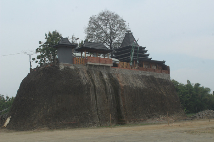 Masjid Buyut Sona yang berdiri di atas bukit dan dikelilingi galian C yang masih aktif di Desa Karangpakis.