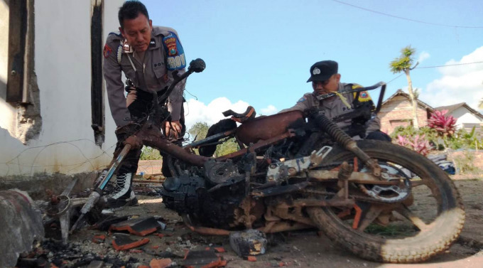 Polisi memeriksa sebuah kerangka motor yang habis terbakar di Desa Mulyorejo, Kecamatan Silo, Jember.