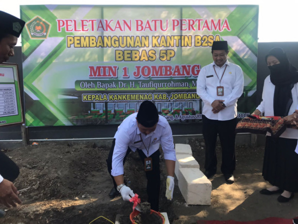 Kepala Kemenag Jombang Dr Taufiqurrohman didampingi Kasi Penma Arif Hidayatullah meletakkan batu pertama pembangunan kantin sehat di MIN 1 Jombang.  (AINUL HAFIDZ/JAWA POS RADAR JOMBANG)