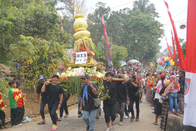 Warga Wonomerto melakukan arak-arakan tumpeng hasil bumi jkeliling desa.