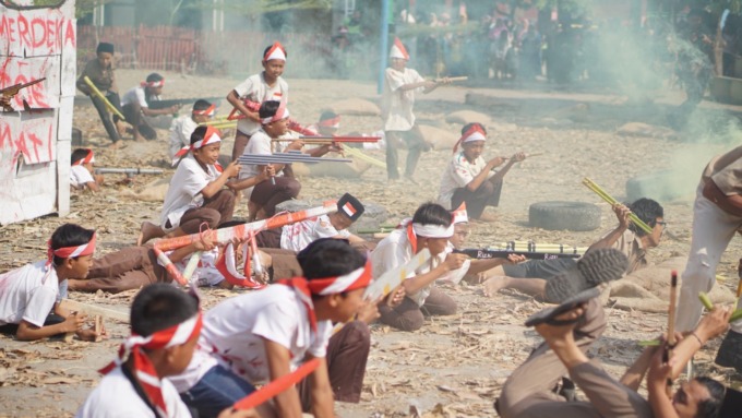 Anak-anak SD sedang berperan menjadi pejuang yang melawan penjajah.