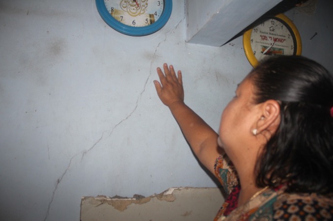Salah satu warga menunjukkan dinding rumah mereka yang retak akibat pemasangan pancang tanggul brantas di Desa Jatiduwur, Kecamatan Kesamben. (AINUL HAFIDZ/JAWA POS RADAR JOMBANG)