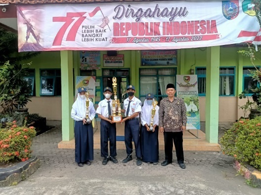 Kepala SMPN 2 Mojowarno Muji Suwanto saat memberikan piagam kejuaraan lomba Giat Prestasi Pramuka Penggalang dan lomba Pramuka Grebada dan O2SN