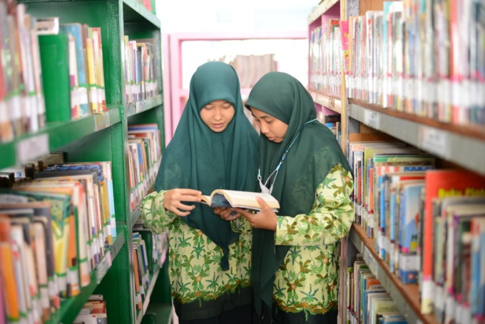 Dua pelajar tengah mengunjungi perpustakaan.