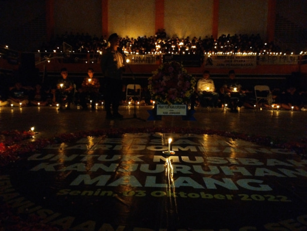 Momen saat ribuan suporter bola di Jombang memanjatkan doa bersama dan menyalakan ribuan lilin di Gor Merdeka Jombang kemarin.