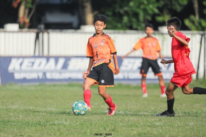 Pemain SSB Bintang Muda Jombang U15 (oranye) saat tampil Piala Soeratin 2022 di Stadion Merdeka Jombang.