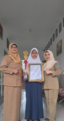 Novia Dewi Pancamita bersama karya desain batiknya yang akan diproduksi masal.