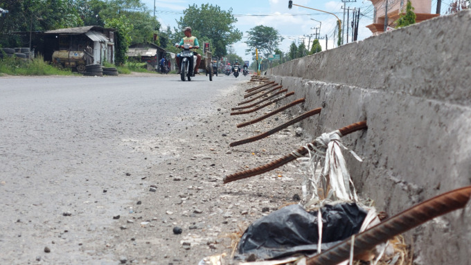 Besi cor di Jalan Nasional Desa Temuwulan, Perak dibiarkan mencuat dan membahayakan pengguna jalan.