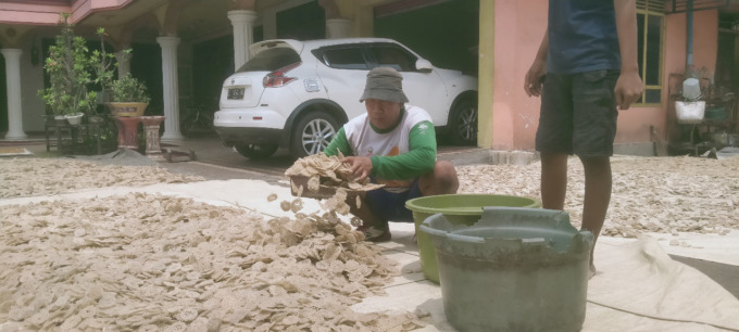 pekerja di rumah Susilo Edi Cahyono  sedang mengangkat kerupuk yang telah dijemur