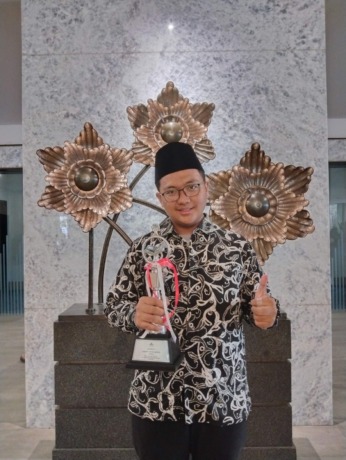 Alif menenteng piala juara 1 MTQ nasional di Kalimantan selatan (17/10).