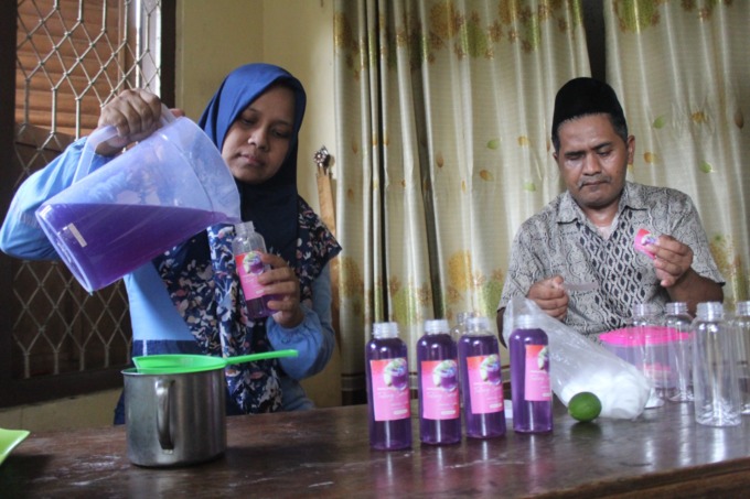 Mulyati Ningsih, 40, dan Aziz Aly, 47 sedang membuat minuman herbal yang berbahan dasar bunga telang