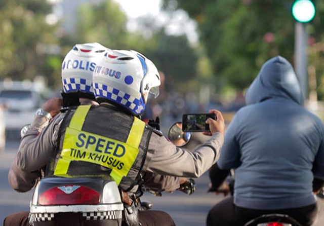 Anggota Satlantas Polrestabes Surabaya mengambil foto pelanggar lalu lintas di sekitar Satpas Colombo. (Satlantas Polrestabes Surabaya untuk Jawa Pos)