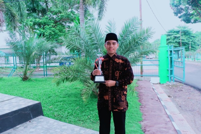 Muhammad Za’im Muhyiddin menunjukkan trofi juara 1 MTQ nasional di Banjarmasin, Kalimantan Selatan 10-19 Oktober 2022.