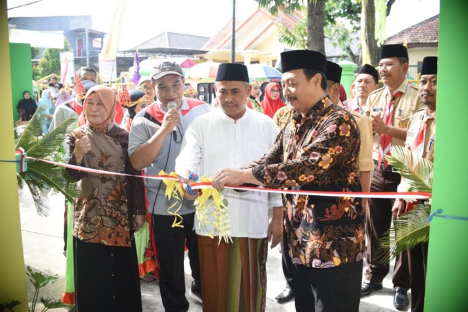 Kepala MAN 8 Jombang, Farida Priyatna, Ketua Komite KH Haris Munawir dan Wakil Ketua Pramuka Kwarcab Jombang, Muhdlor dan Kepala Kemenag Taufiqurrohman memotong pita peresmian ruang PTSP.
