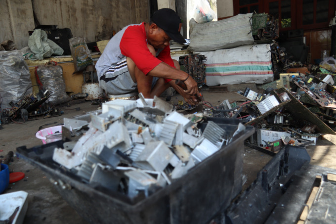 Yani, warga Dusun/Desa Bulurejo, Kecamatan Diwek saat menguliti barang elektronik bekas di rumahnya,