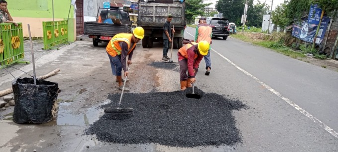 Petugas dari Dinas PUPR Jombang menambal jalan berlubang di ruas Gambiran-Selorejo.