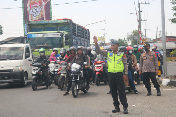 Petugas kepolisian mengatur lalu lintas dengan sistem buka tutup di simpang Bangjuri (Jombang-Nganjuk-Kediri) untuk mengurai kemacetan.
