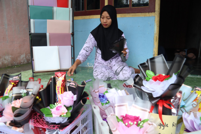 Choirul Hidayah, 41, saat merangkai buket bunga di rumahnya.  Usahanya ini, selalu ramai dipesan jelang wisuda dan kelulusan.