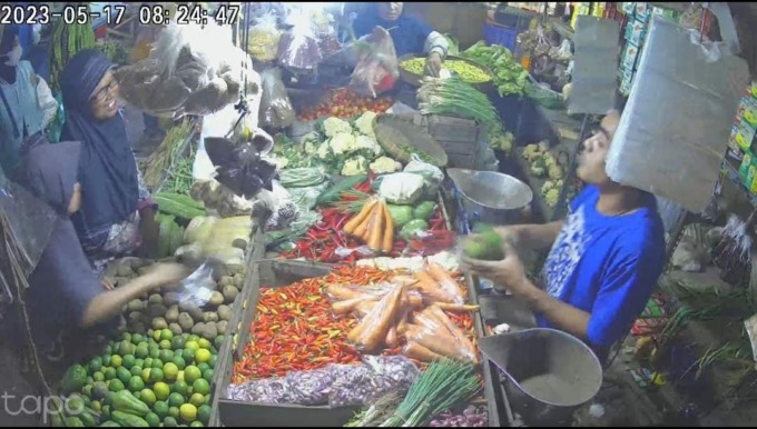 Emak-emak berkerudung hitam (tengah) saat menjalankan aksinya mencuri HP milik penjaga toko lapak sayur di Pasar Pon Jombang