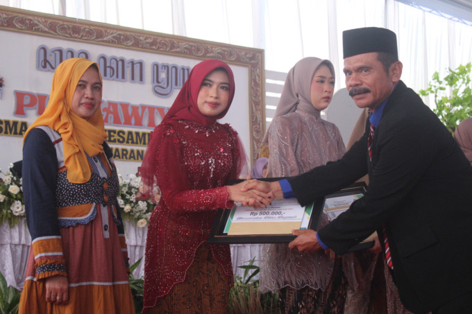 Plt Kepala SMAN Kesamben Ba’i bersama lulusan berprestasi.