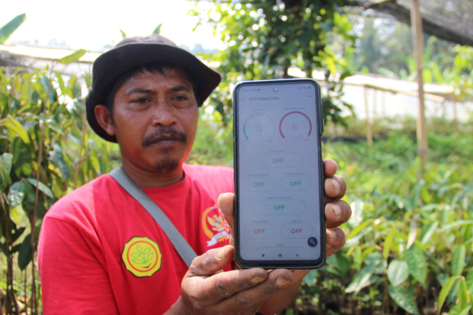 Suyitno pembibit durian di Dusun Sumber, Desa Wonosalam, Kecamatan Wonosalam mengecek kondisi tanaman melalui aplikasi.
