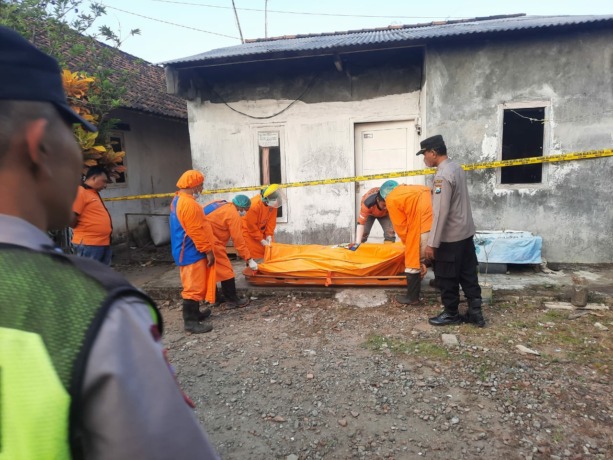 Petugas sedang mengevakuasi jasad Supriyadi dari rumah kontrakannya dengan menggunakan kantong mayat untuk dibawa ke RSUD Jombang