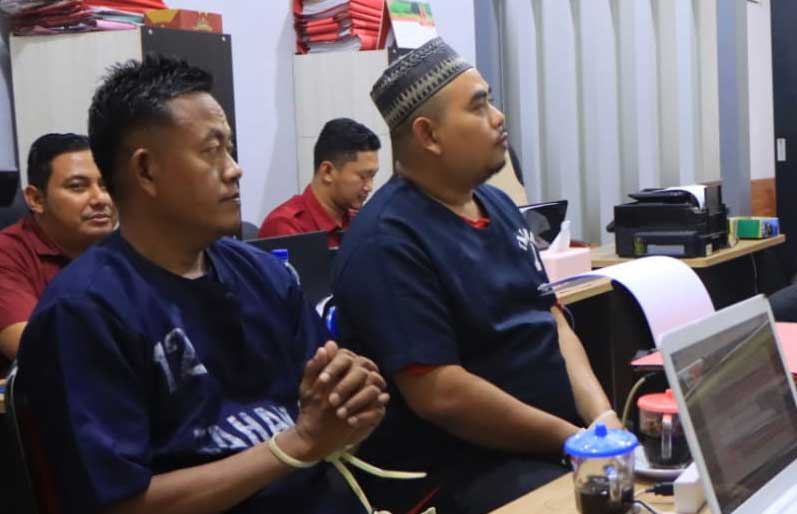 DIAMANKAN: Dua tersangka yang berperan sebagai pengepul dan pengecer togel saat diamankan di Polres Tuban. (Yudha Satria Aditama/Radar Tuban)