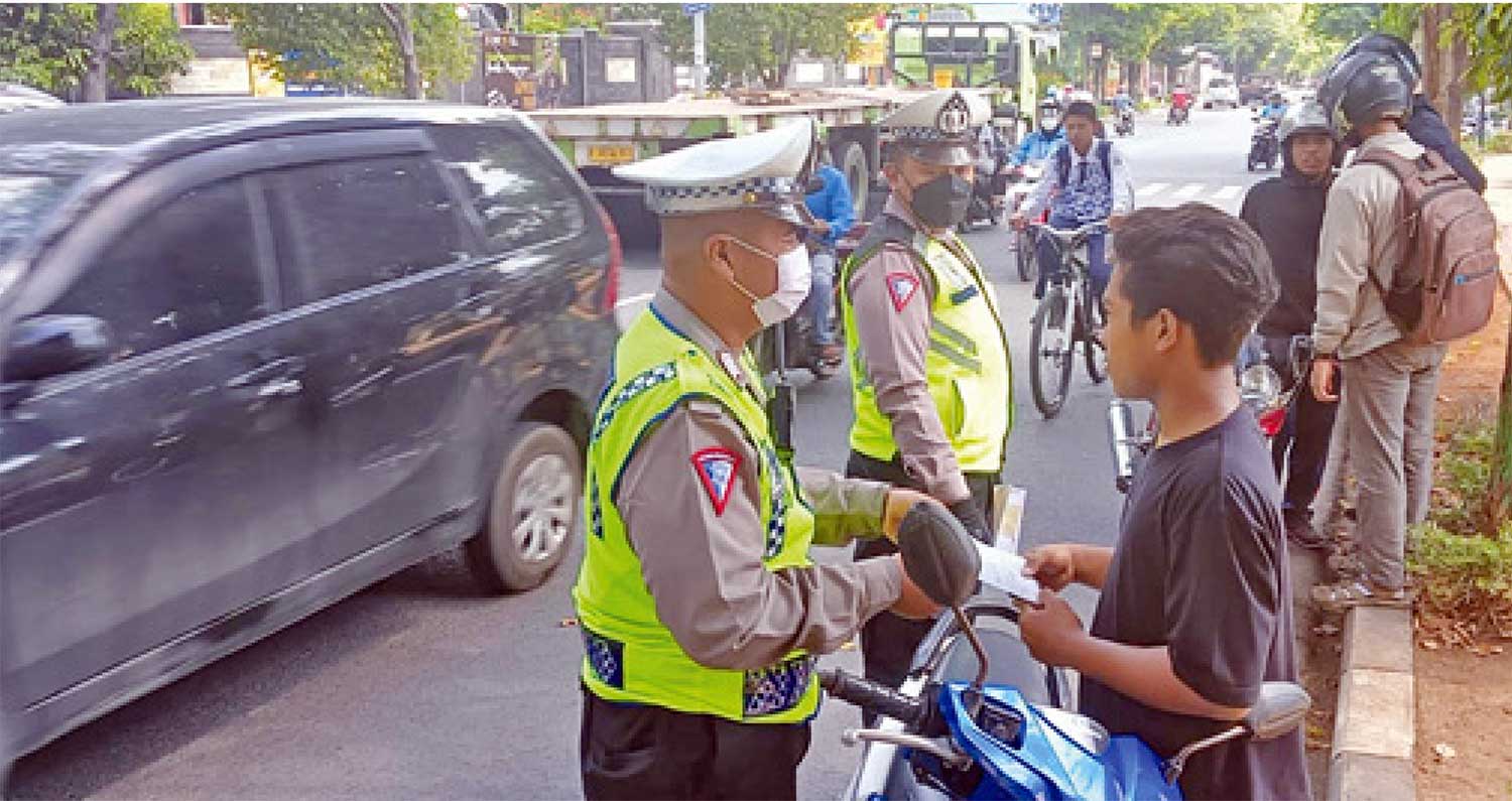 JARING PELANGGAR: Pengendara motor yang tidak mengenakan helm terjaring razia di Jalan Wahidin Sudirohusdo. (Yudha Satria Aditama/Radar Tuban)