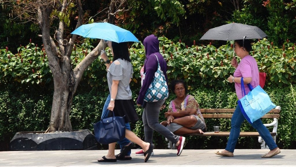 Warga menggunakan payung untuk menghindari sengatan matahari ketika berjalan di sekitar Bunderan HI, Jakarta. (ANTARA)