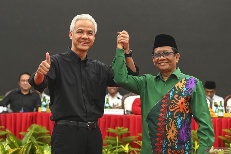 Bakal calon presiden dari PDI Perjuangan (PDIP) Ganjar Pranowo (kiri) dan bakal calon wakil presiden Mahfud MD (kanan) bergandengan tangan saat acara pengumuman bakal calon wakil presiden pada Pilpres