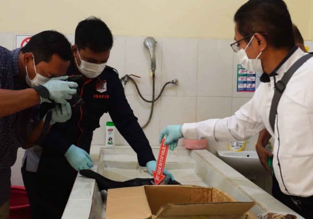 EVAKUASI: Petugas Polsek Jenu saat melakukan visum di ruang mayat RSUD dr. R. Koesma, Tuban.