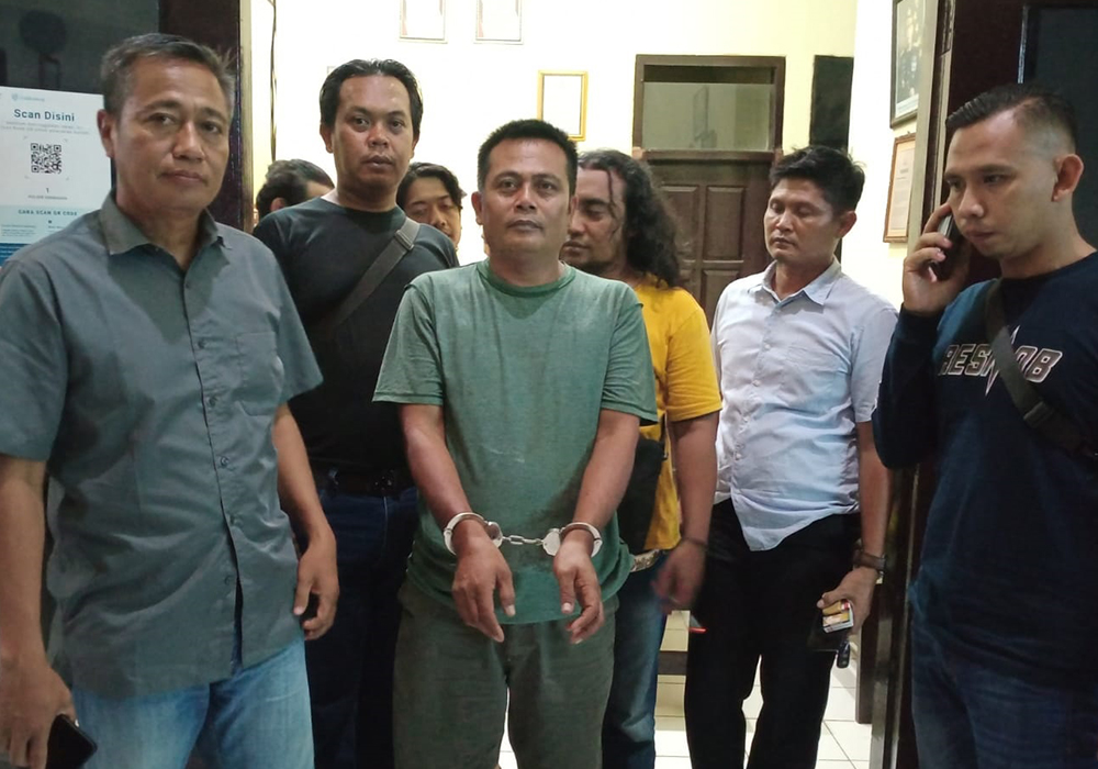 MENYERAHKAN DIRI: Jano, 45, dengan tangan terborgol saat ditunjukkan kepada awak media, Rabu (11/10).