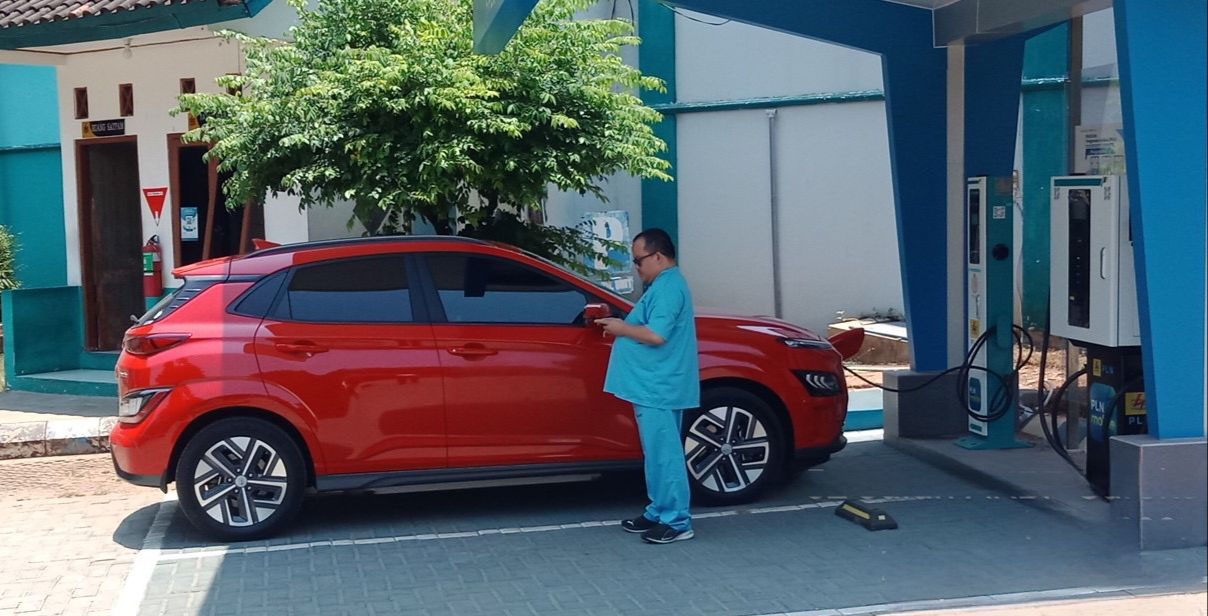 ISI DAYA: Pengguna mobil listrik saat mengisi daya baterai mobil di SPKLU PLN Tuban, Jalan AKBP Suroko.