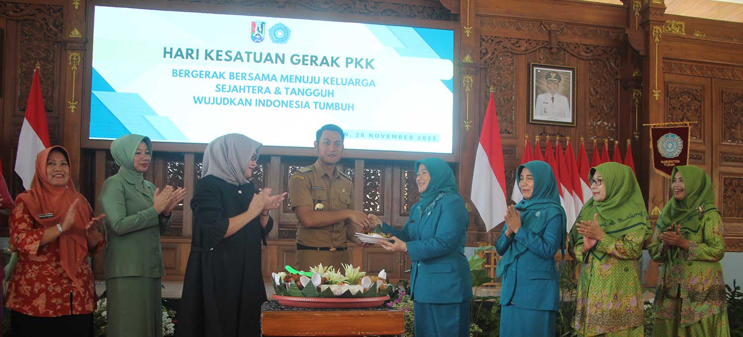 Bupati Aditya Halindra Faridzky didampingi Anggota DPR RI Haeny Relawati Rini Widyastuti memberikan potongan tumpeng kepada Ketua TP PKK Tuban Hart Novembria Susetyowati pada puncak peringatan HKG.