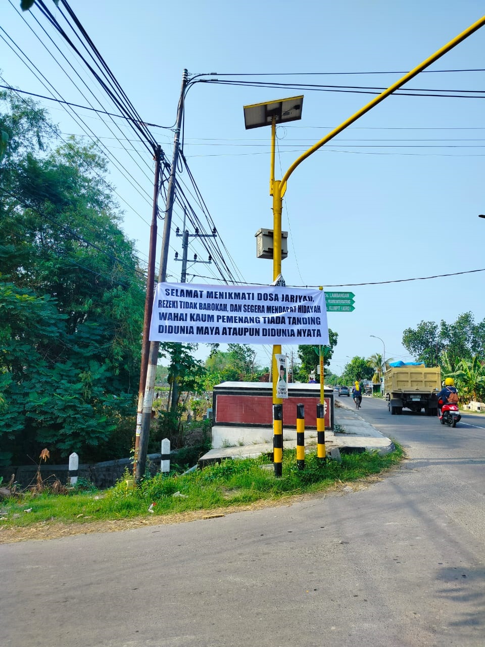 TERUS BERSUARA: Banner sindiran terhadap pemilihan perangkat desa di Sokosari, Kecamatan Soko yang terpasang di jalan desa setempat.