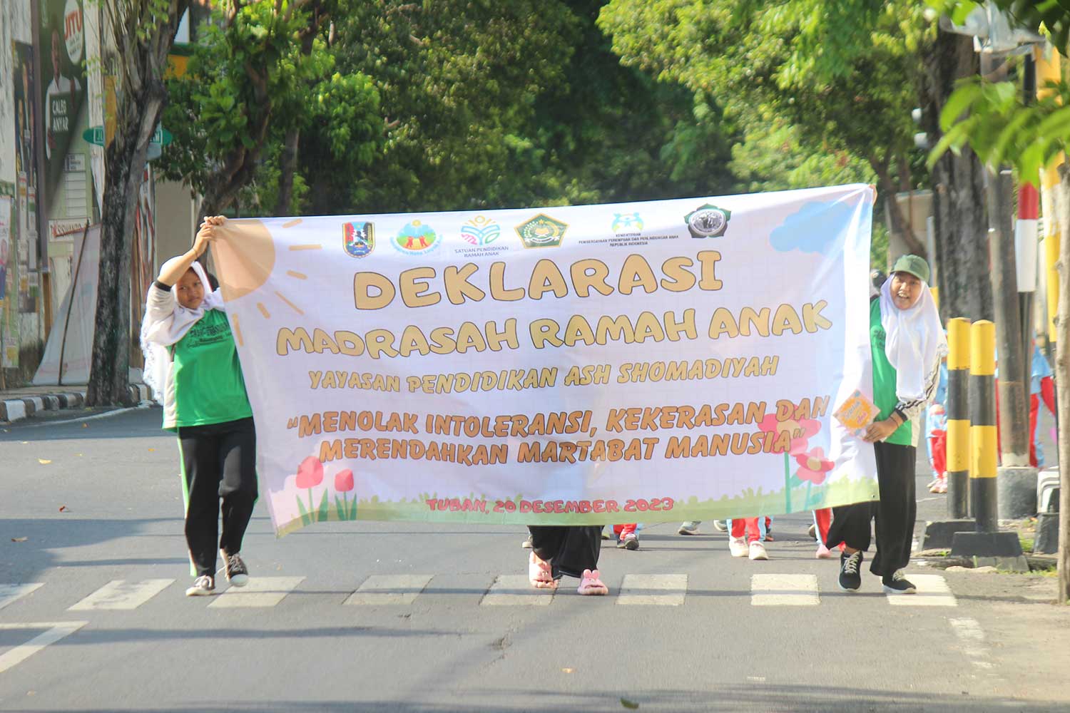 AKSI NYATA: Santri Ash Shomadiyah Tuban saat membentangkan banner Deklarasi Madrasah Ramah Anak pada jalan sehat.