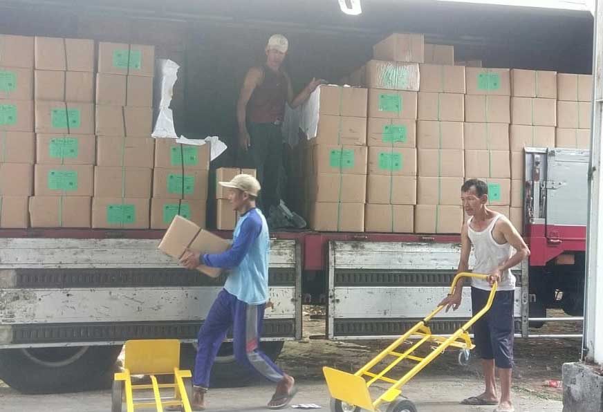 DIJAGA KETAT: Petugas KPUK Tuban menurunkan kotak suara yang baru saja datang, Rabu (27/12). Proses pengiriman dengan pengawalan ketat.