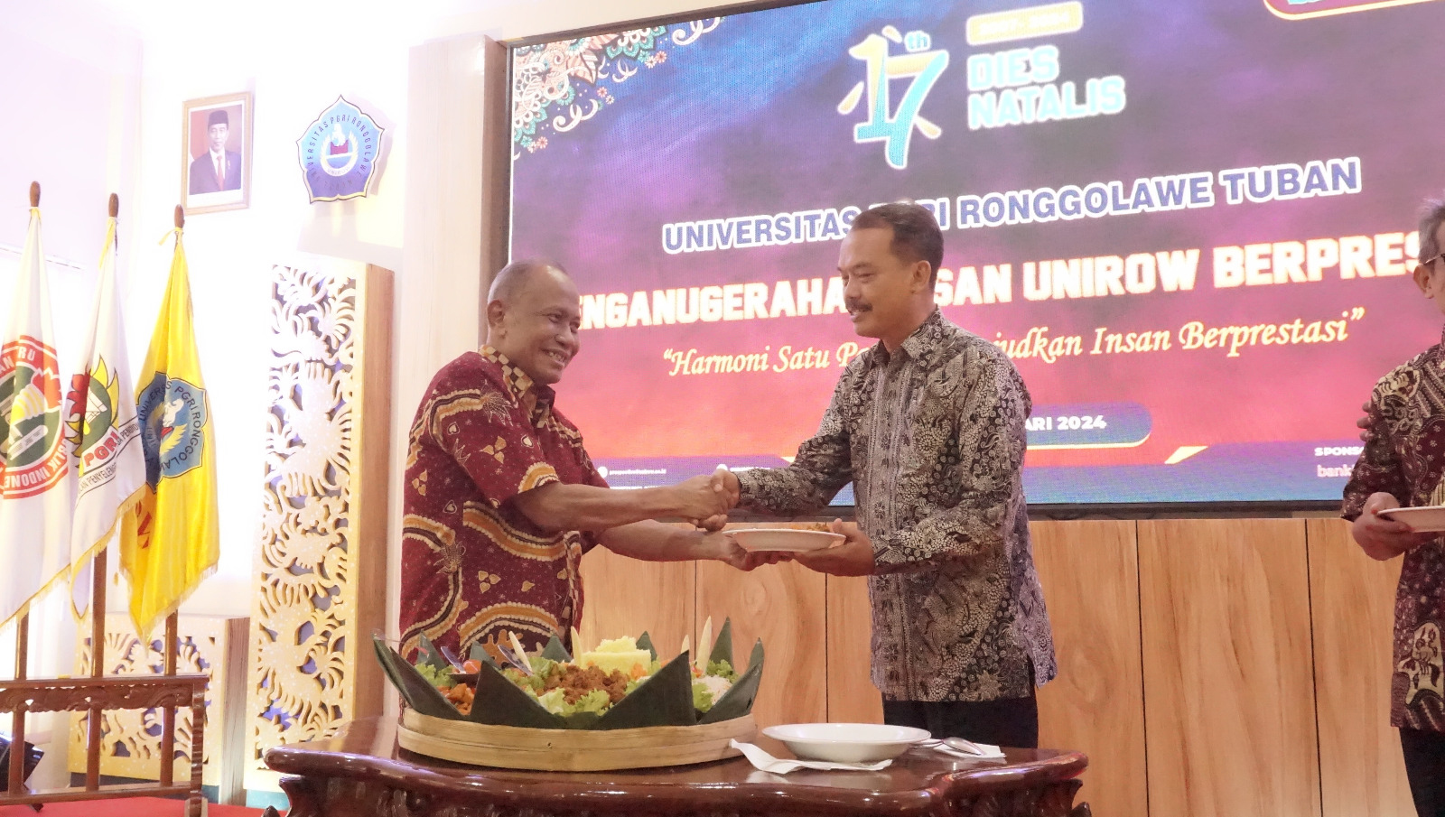 HARMONIS: Penyerahan potong tumpeng dari ketua PPLP PT PGRI Tuban kepada perwakilan keluarga pendiri dan perintis Unirow.