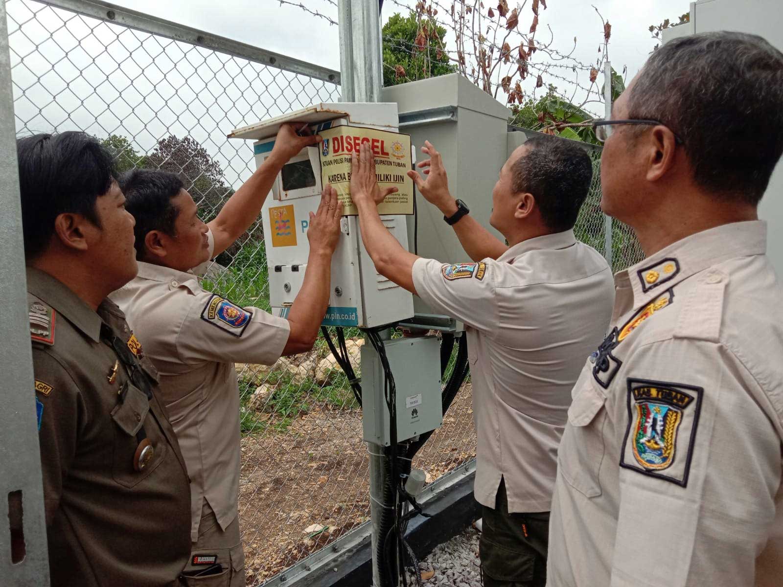 ILEGAL: Tim Satpol PP-Damkar Tuban menyegel salah satu menara telekomunikasi di Desa Ketambul, Kecamatan Palang beberapa hari lalu.