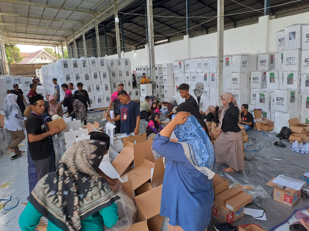MENUJU COBLOSAN: Petugas packing di gudang logistik KPUK Tuban menyiapkan logistik pemilu sebelum proses distribusi.