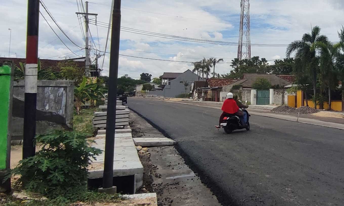 MENGHALANGI: Tiang jasa telekomunikasi yang masih tertancap di area drainase Jalan Soekarno Hatta, Tuban.