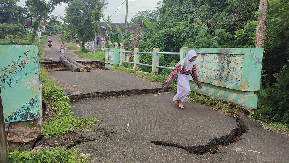TETAP MELINTAS: Masyarakat di Dusun Silir, Desa Dikir, Kecamatan Tambakboyo tetap melintasi jembatan meski kondisinya cukup membahayakan.